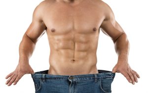 Weight loss, close up of muscular built man wearing too large jeans